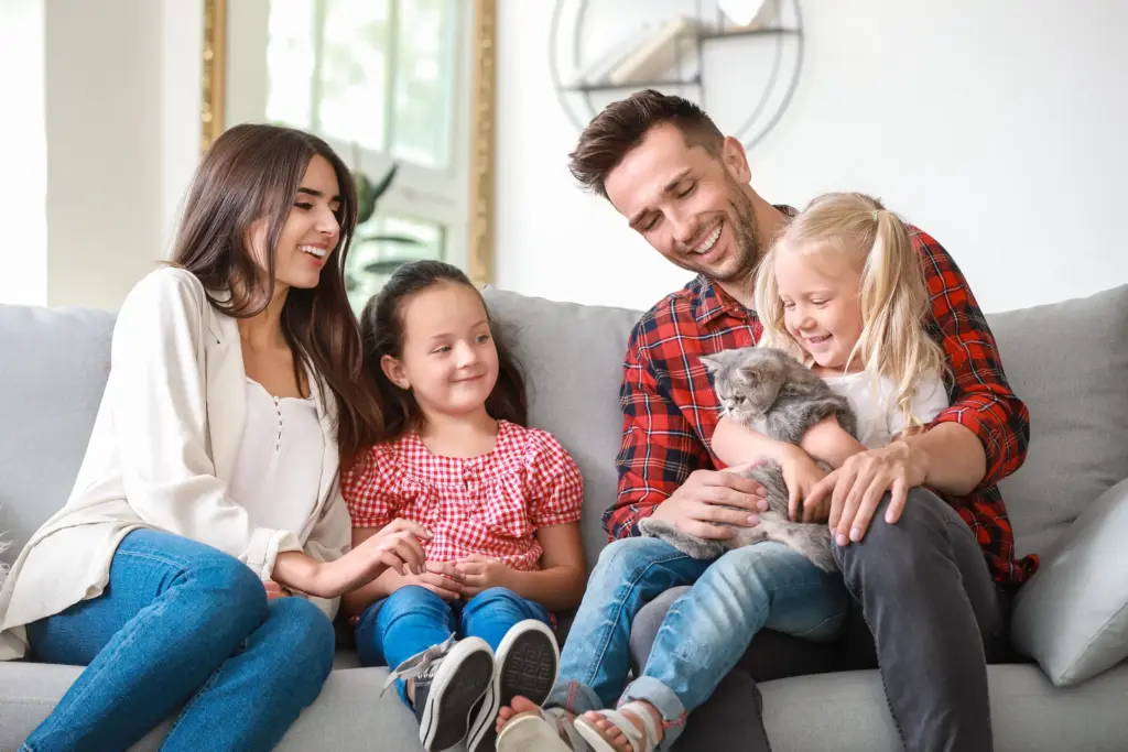 Happy family with cute cat resting at home